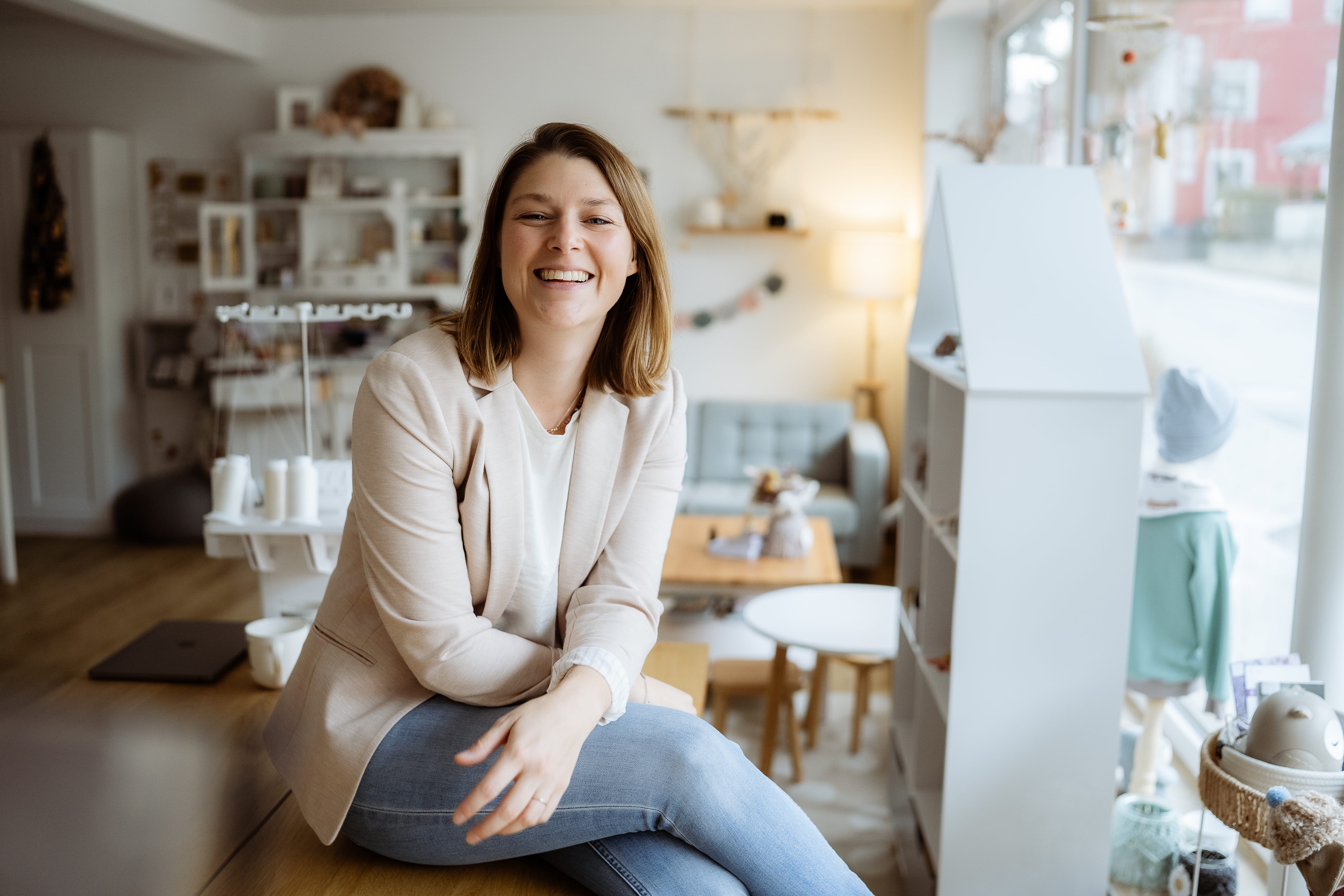 Sandra, lächelnd in einem hellen Studio mit Regalen und Tageslicht — Roots & Soul.